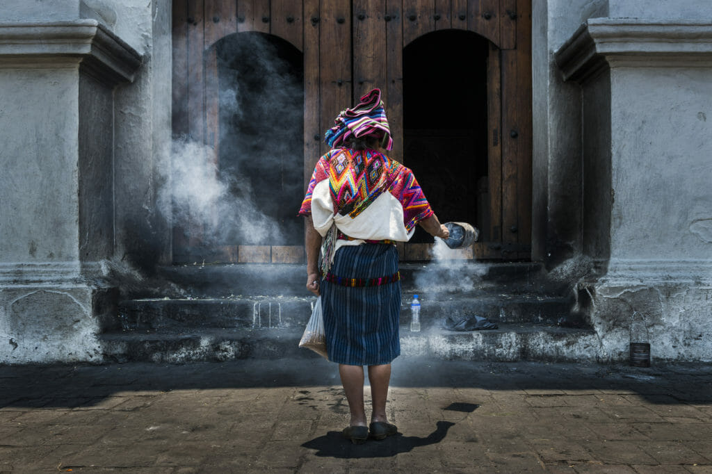 Reasons to visit Guatemala woman performing a tirual in front of church in Chichicastenando